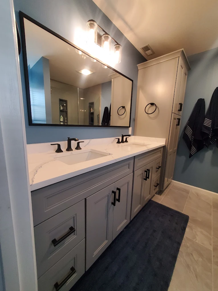 Luxury bathroom remodel with modern fixtures, white tile, and glass shower door in Southern NH