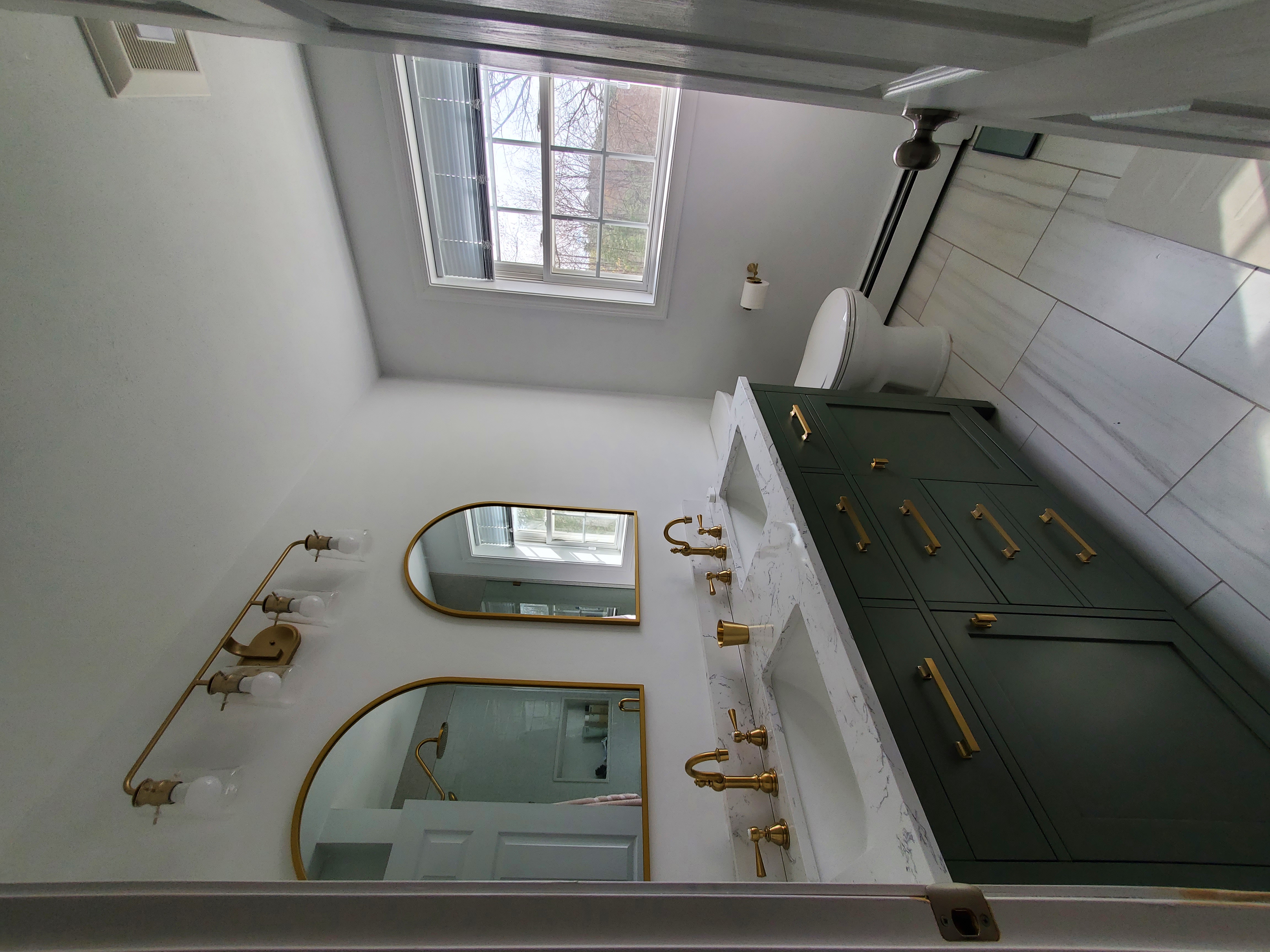 Beautifully remodeled bathroom with brass fixtures and porcelain tile in NH