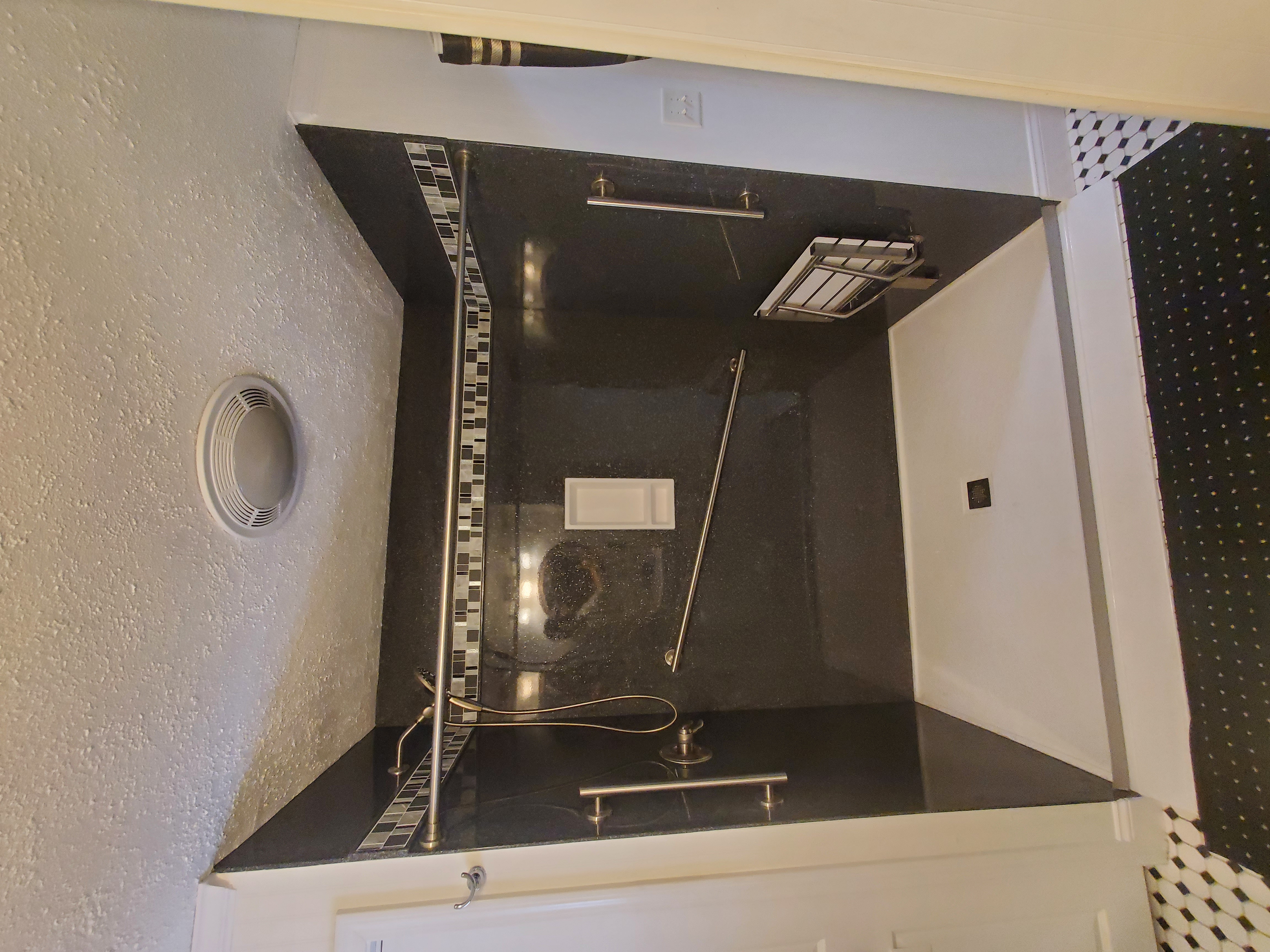 Custom solid stone panel ada accessible shower with grab bars and bench