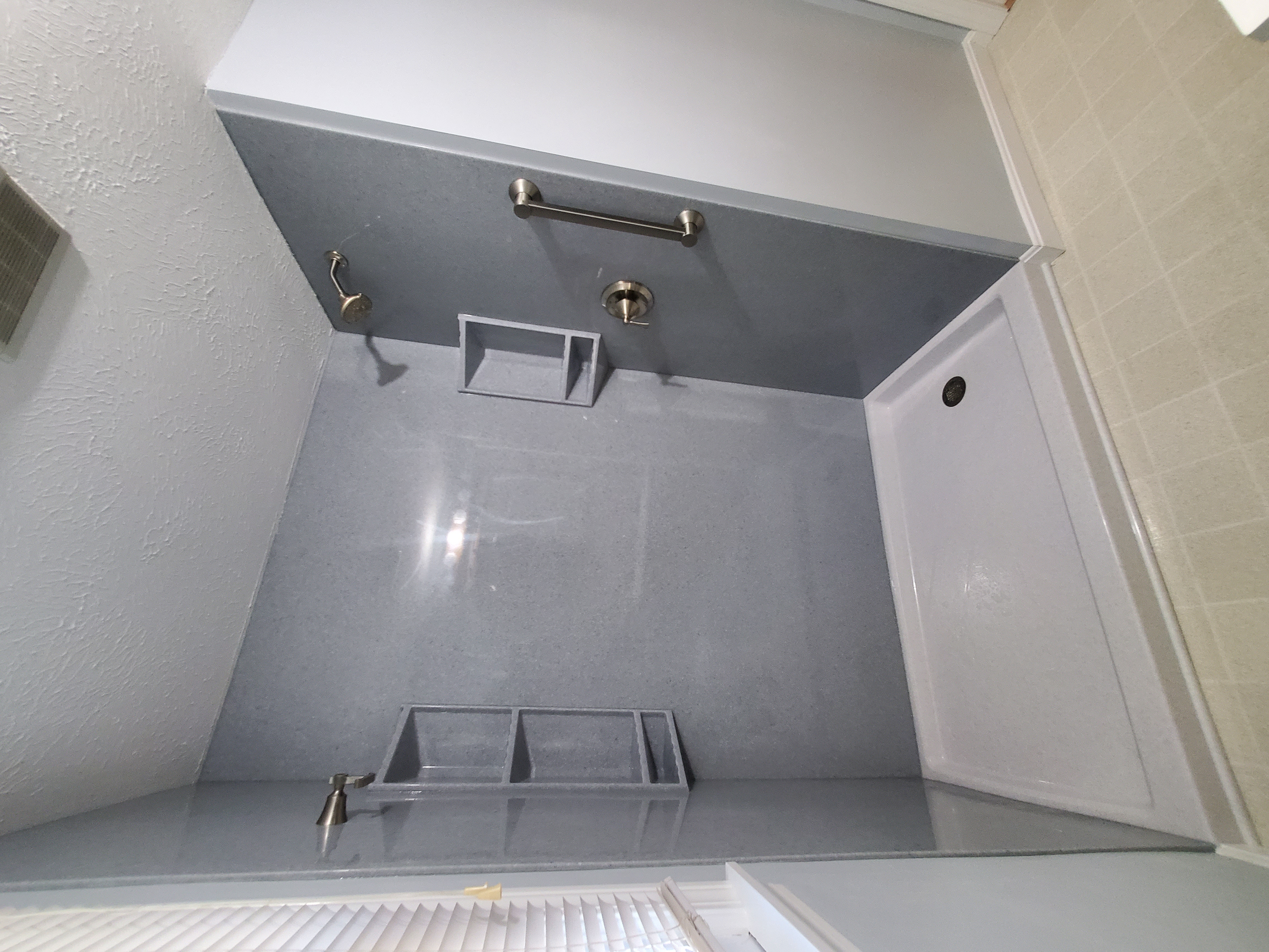 Tub to shower replacement with solid stone shower walls and corner shelves