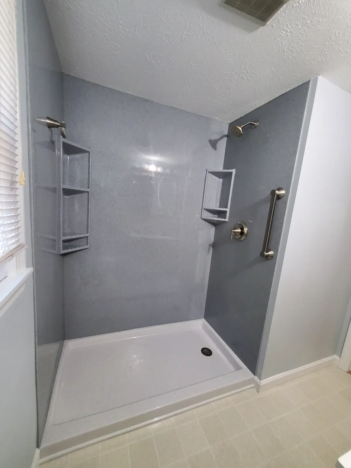 Tub to shower replacement with solid stone shower walls and corner shelves